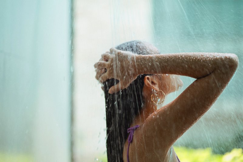 Eine Frau duscht sich in ihrem Garten
