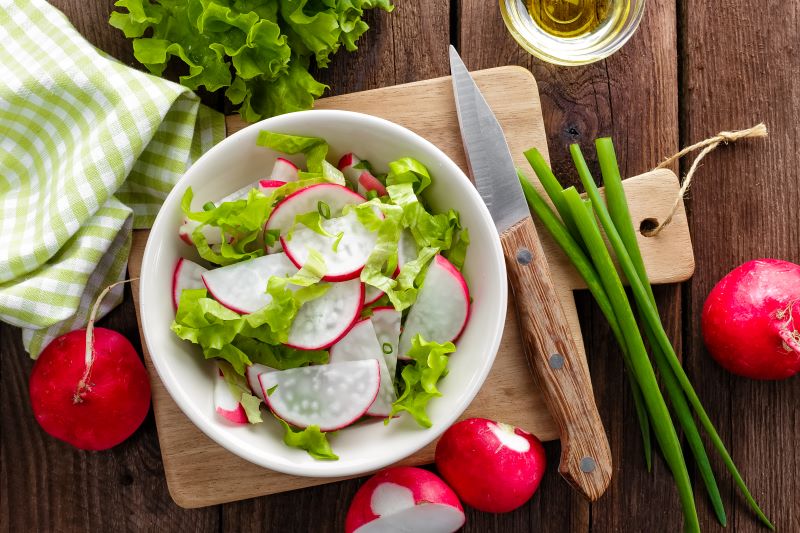 Radieschen und Salat auf einem Brettchen