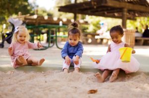 Drei Kinder, die im Sandkasten spielen