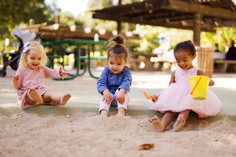 Drei junge Mädchen beim Spielen im Sandkasten